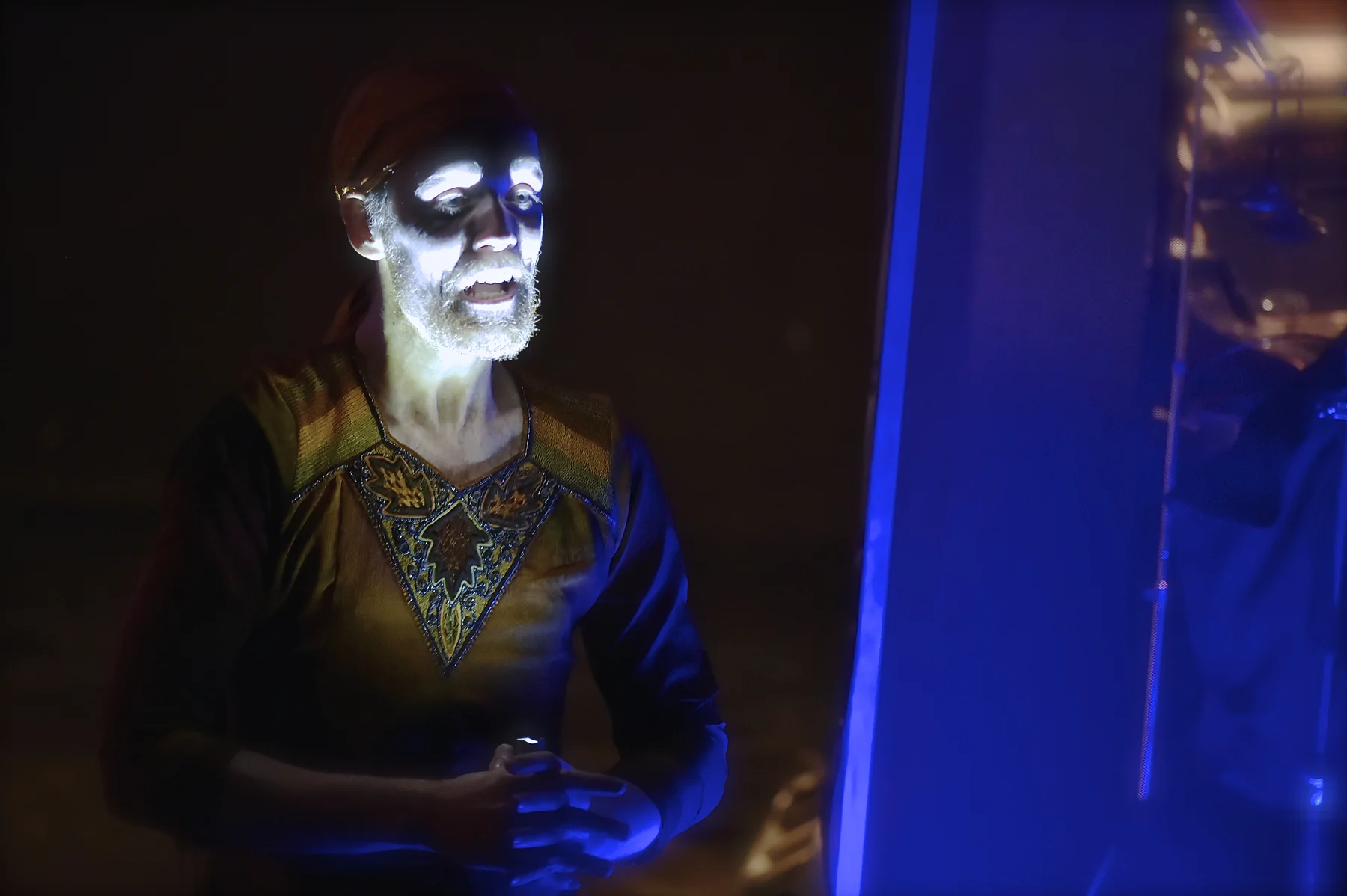 Marcus Brody performing under blue stage light